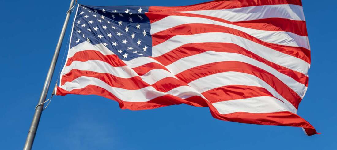 Flagge der USA weht vor blauem Himmel