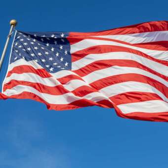 Flagge der USA weht vor blauem Himmel